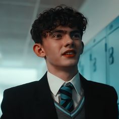 a young man in a suit and tie looking at the camera with an intense look on his face