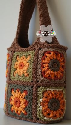 a crocheted bag with sunflowers on the front and sides, hanging from a hook