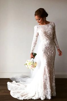 a woman in a long sleeved wedding gown