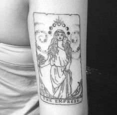 a woman's arm with a tarot card tattoo on it