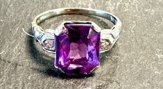 14k Deco ring with a man made faceted rectangular Sapphire with Diamonds on each side.  Condition is very good I see no problems, pictures show the details.  Size 7,  6.5/16" north to south on finger, wt.- 2.4 grams.  The color and cut on the Sapphire is lovely, flashes of intense purple and pink. It is a signed American Beauty ring and stamped 14K, circa 1930s American.  Classic timeless design. Formal Purple Rings With Rectangular Stone, Purple Emerald-cut Ring For Formal Occasions, Purple Emerald Cut Ring For Formal Occasions, Formal Purple Emerald Cut Ring, Purple Baguette Cut Rings For Formal Occasions, Classic Emerald Cut Purple Rings, Classic Purple Emerald Cut Rings, Formal Purple Platinum Rings, Classic Amethyst Rectangular Ring For Anniversary