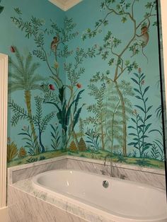 a bath tub sitting under a painting on the wall