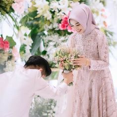 a man kneeling down next to a woman holding flowers