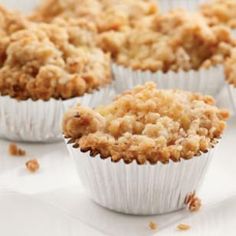 muffins with crumbs are sitting on a white tablecloth, ready to be eaten