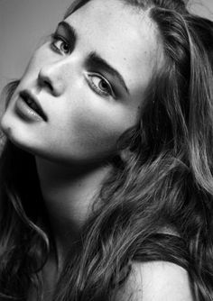 a woman with long hair is posing for a black and white photo, her eyes are open