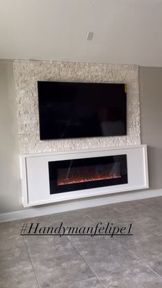 a flat screen tv mounted on the wall above a fireplace