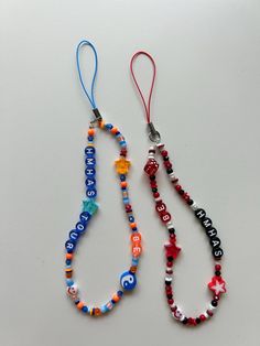 two necklaces with beads and letters on them sitting next to each other, one has a star