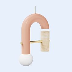 a pink and white object hanging from a hook on a blue wall next to a light bulb