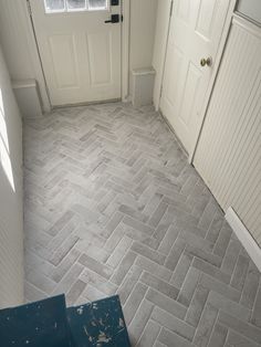 an empty room with white doors and gray tile flooring on the side of the door