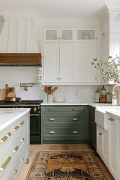 a kitchen with green cabinets and white counter tops, an area rug on the floor