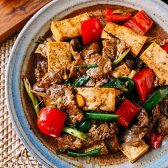 a bowl filled with tofu and vegetables on top of a table