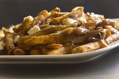 a white plate topped with french fries covered in gravy and melted marshmallows