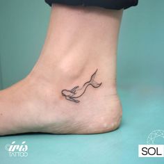 a small tattoo on the foot of a woman's foot with a bird flying above it