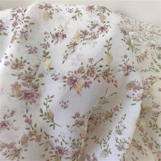 the fabric is white with pink flowers on it