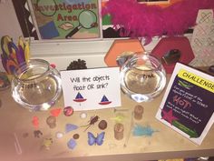 a table topped with two clear bowls filled with coins and other items on top of it