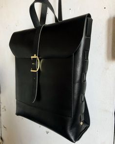 "sleek and variable all black rucksack tote with all solid brass hardware.  made with a woven side detail and all black leather.  measures 15\"x14\"x4 with a large exterior pocket and a spacious main section" Black Leather Backpack With Gunmetal Hardware, Black Satchel With Brass Hardware For Everyday, Everyday Black Satchel With Brass Hardware, Classic Black Backpack With Leather Handles, Black Rucksack, Black Convertible, Holster Bag, Black On Black, Backpack Purse