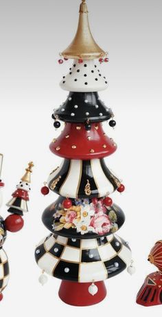 three ceramic christmas trees are shown in different colors and designs, one is red, the other is black