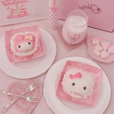 two hello kitty cakes sitting on top of plates next to a cup and saucer