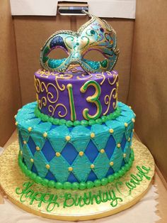 a birthday cake decorated with a masquerade and mardi gras mask on top