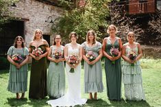 a group of women standing next to each other on top of a lush green field