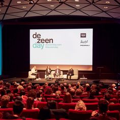 people are sitting on chairs in front of a screen with the words de zeen day