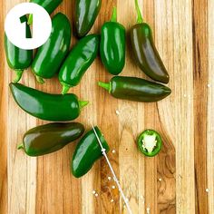 several green peppers on a wooden cutting board