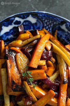 a blue and white bowl filled with cooked carrots