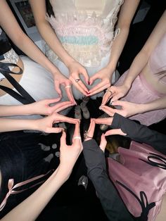 a group of people standing in a circle with their hands on top of each other