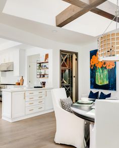 a dining room and kitchen area with white furniture