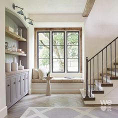 a living room filled with furniture next to a window covered in windowsills and shelves