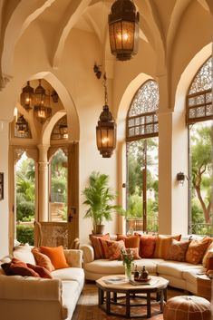 a living room filled with lots of furniture and large arched windows above the couches