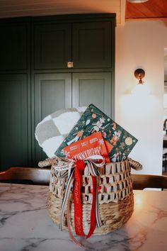 a basket filled with books sitting on top of a counter next to a light fixture