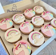 twelve cupcakes in a box decorated with pink, white and blue icing