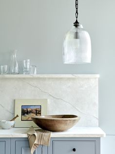 a bowl sitting on top of a counter next to a glass vase and other items