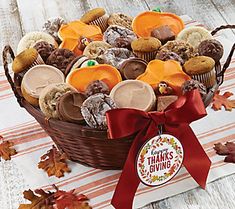 a basket filled with lots of treats on top of a wooden table covered in leaves