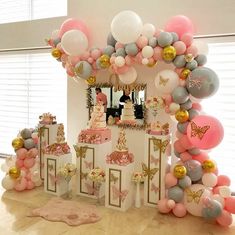 a table topped with lots of balloons and cake