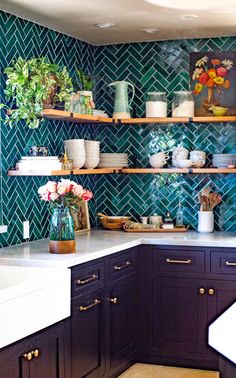 a kitchen filled with lots of counter top space and wooden shelves covered in pots and pans