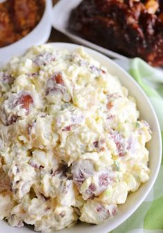 a bowl filled with potato salad next to other dishes