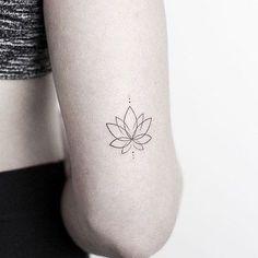 a woman's arm with a small flower tattoo on the left side of her arm