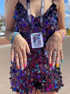 a woman in a purple dress holding onto her hand with colorful beads on it and an id tag attached to her wrist