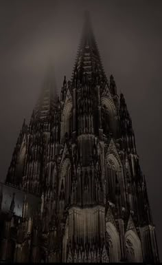 an image of a gothic cathedral in the foggy night with light coming from it