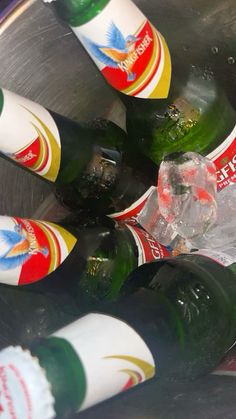 several empty beer bottles in a metal bowl