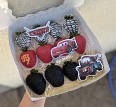 a box filled with chocolate covered strawberries in the shape of cars