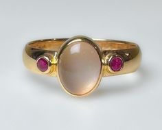 Stunning vintage, midcentury to 1970s...not entirely sure of its age. It does have an older hallmark. This is elegantly crafted ring with a comfortable low profile.  Featuring a clean luminescent 1.5ct Moonstone, flanked by two red Ruby's. Very pretty ring. 3.7g 14k solid yellow gold Hallmarked 4mm wide band Moonstone 1.5 ct Rubies 2 mm ea (.10ct) S 8 Us Resizable Excellent vintage condition Unique Ring Setting, Moonstone Gold Ring, Vintage Ruby Ring, Rubin Ring, Ruby Ring Vintage, June Birthstone Ring, Pretty Ring, Signet Ring Men, Vintage Style Rings