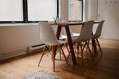 a table with four chairs in front of a window