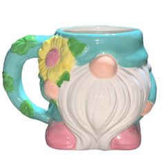 a ceramic mug with a gnome's face and flowers on it