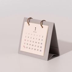 a desk calendar with two rings on the front and one ring in the middle, attached to a stand