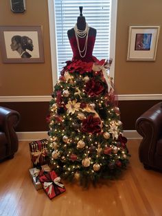 a christmas tree is decorated with red and gold ribbons, poinsettis, and pearls