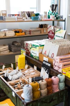 there are many different types of yarns on display in the store, including knitting needles and books