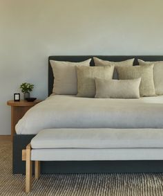 a bed with several pillows on top of it